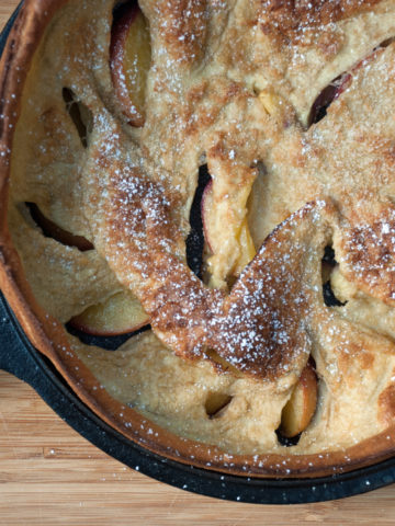 Gluten free peach dutch baby pancake with powdered sugar