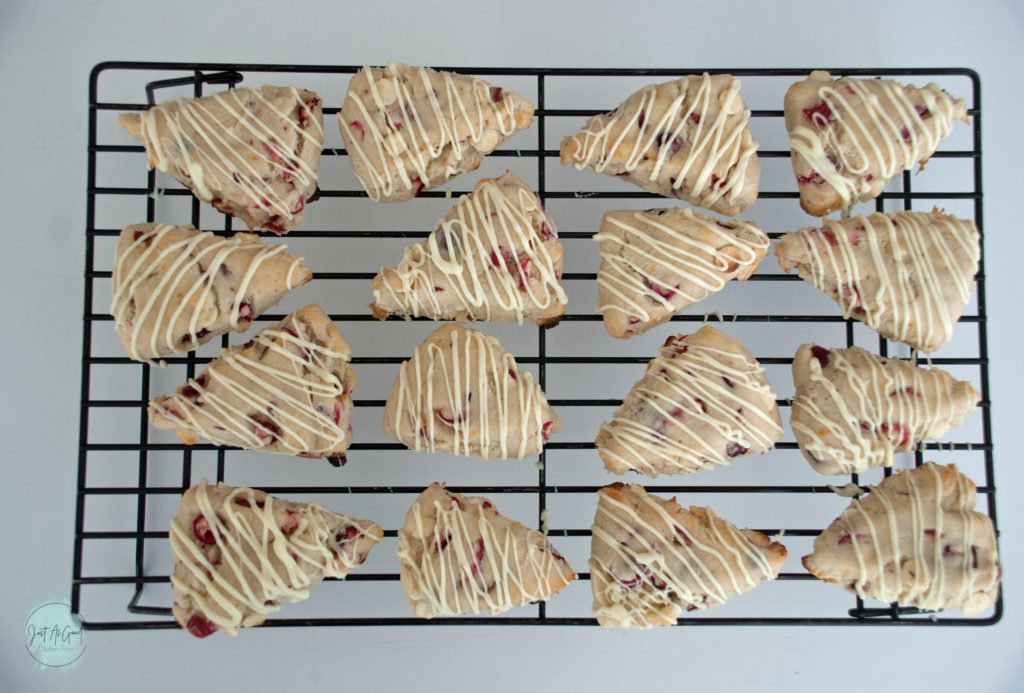 Gluten free white chocolate cranberry scone drizzled on cooling rack