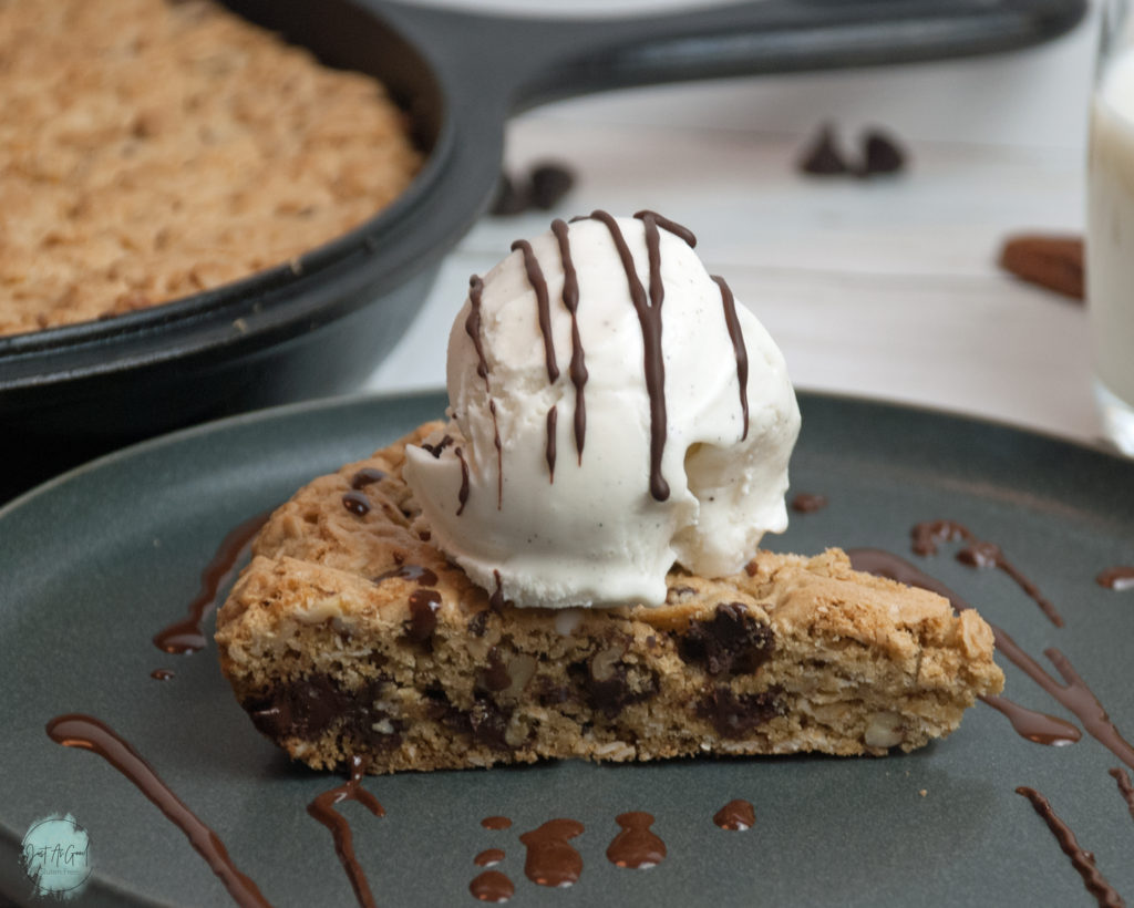 Gluten Free Chocolate Chip Oatmeal Skillet Cookie side view with ice cream and chocolate sauce