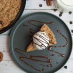 Gluten Free Chocolate Chip Oatmeal Skillet Cookie top view with ice cream and chocolate sauce