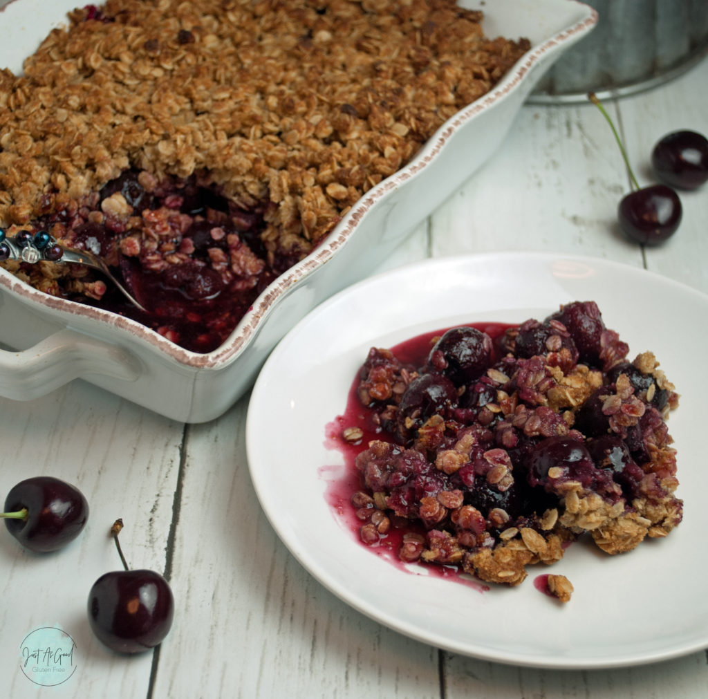 Gluten free cherry crisp on plate with dish behind