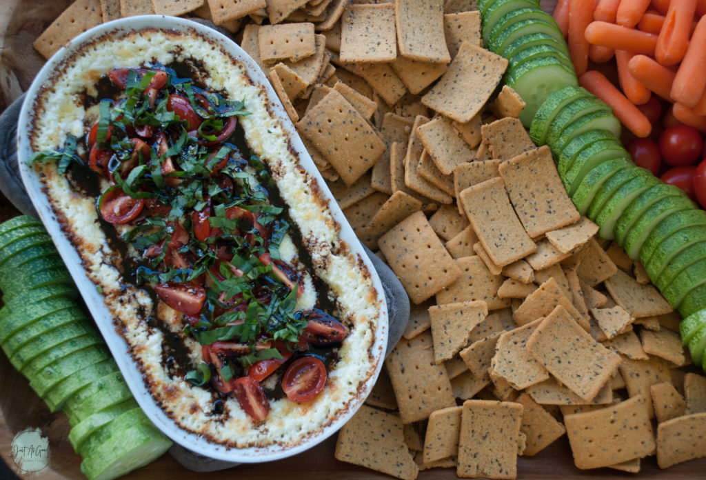 Gluten Free Warm Goat Cheese Caprese Dip Whole Platter with crackers cucumbers tomatoes and carrots