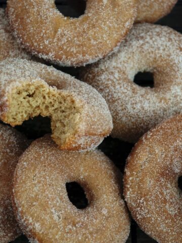 Stack of Gluten Free Baked Apple Cider Donuts with bite on side