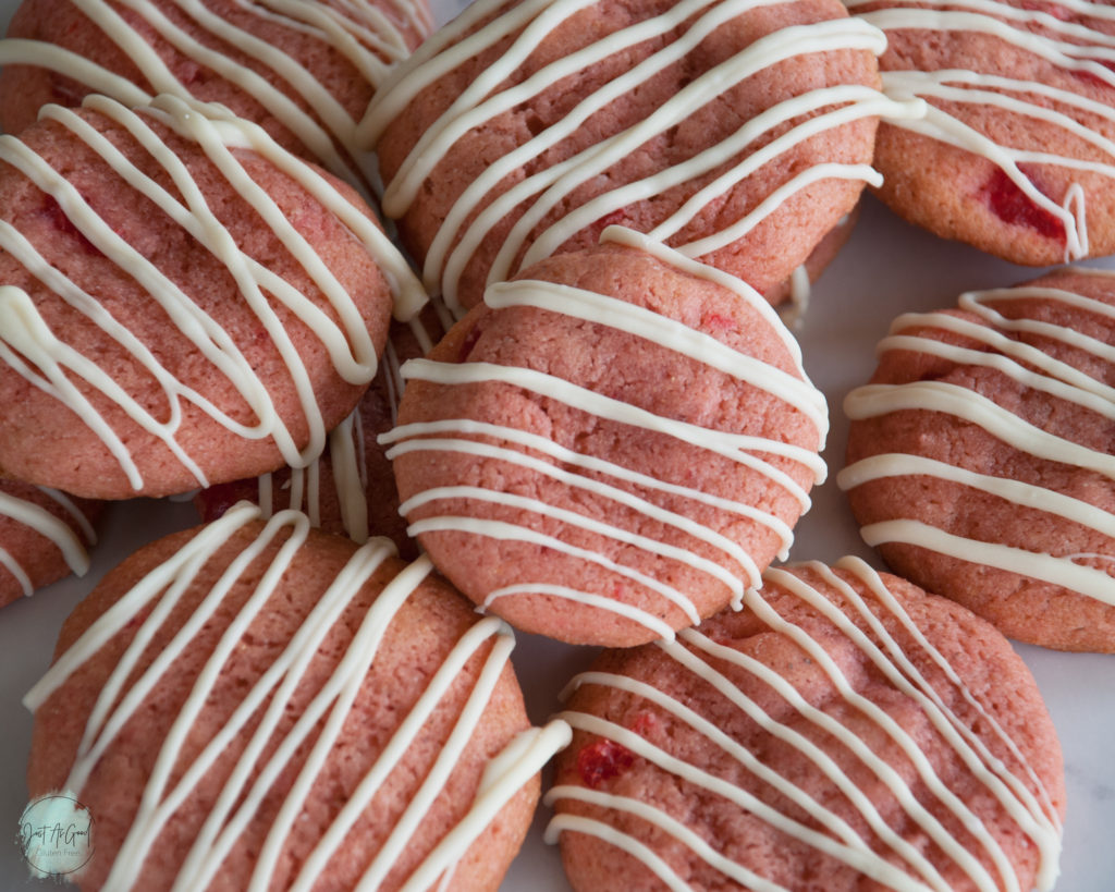 pile of gluten free cherry cookies with white chocolate drizzle