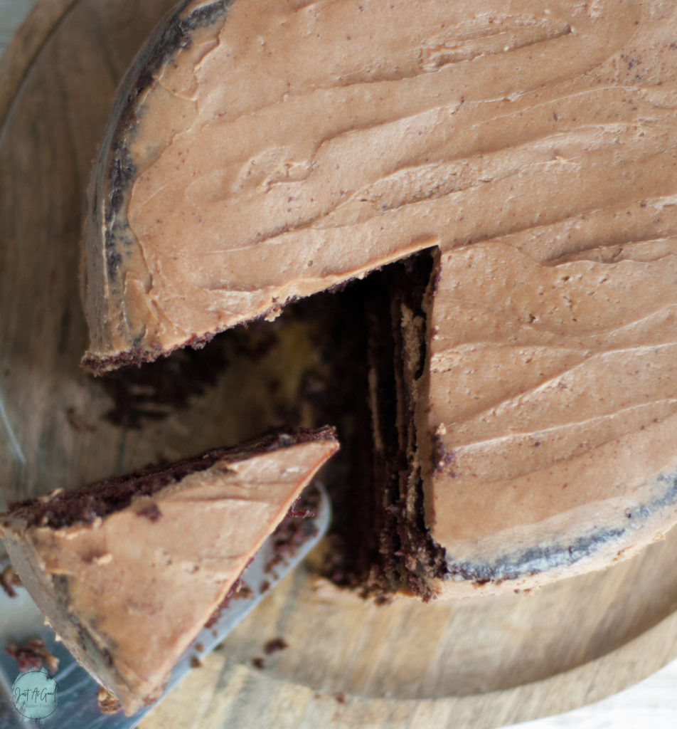 Top view with slice coming out of gluten free chocolate cake with mocha buttercream frosting