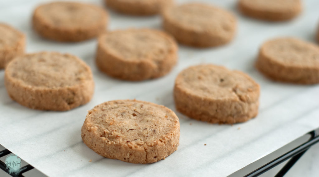 Gluten Free Pecan Shortbread Cookies on parchment paper and cookie rack from side angle