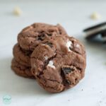 Single cookie in front of stacked Gluten Free Chocolate Cookies and Cream Cookie