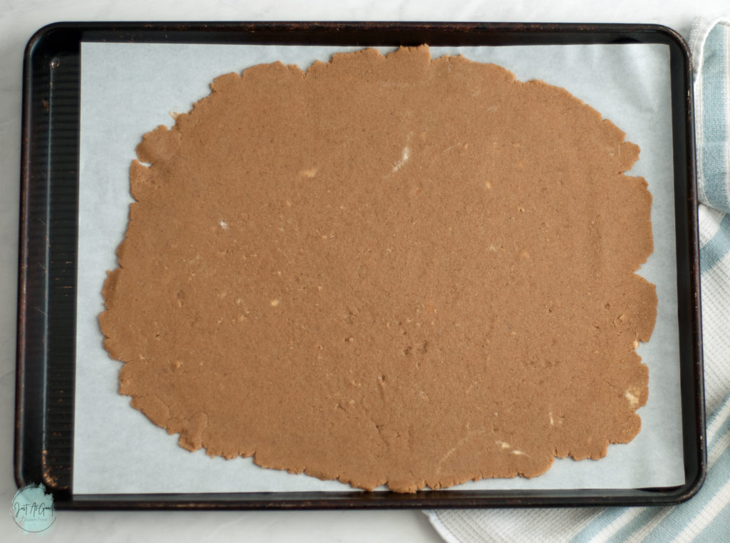 gluten free graham cracker dough rolled out on baking sheet