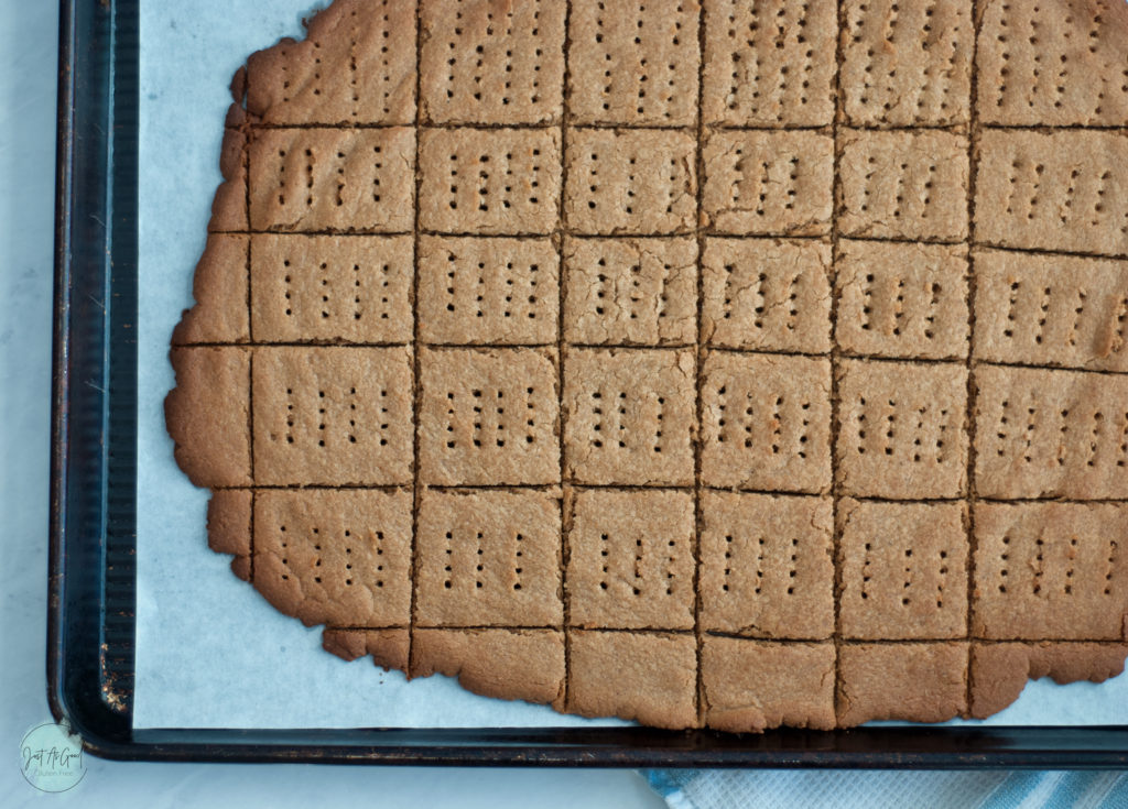 baking sheet of gluten free graham cracker scored with holes poked in crackers