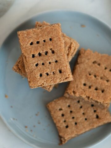 Stack of gluten free tiger nut graham crackers on blue plate