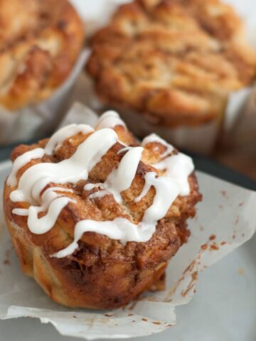 Gluten Free Twisted Cinnamon Buns on plate with drizzled frosting