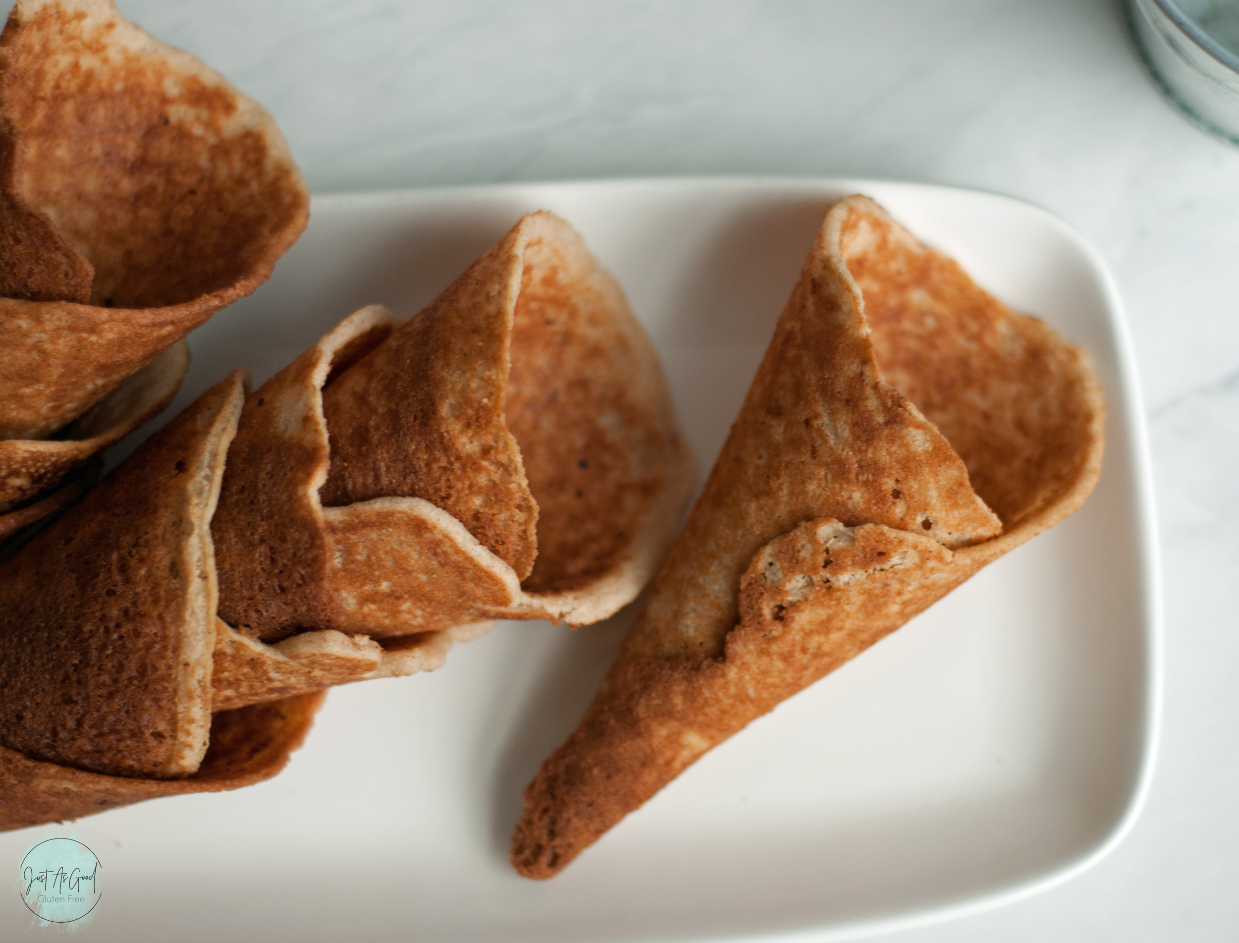 gluten free waffle cones, one single, several stacked inside each other, one white plate