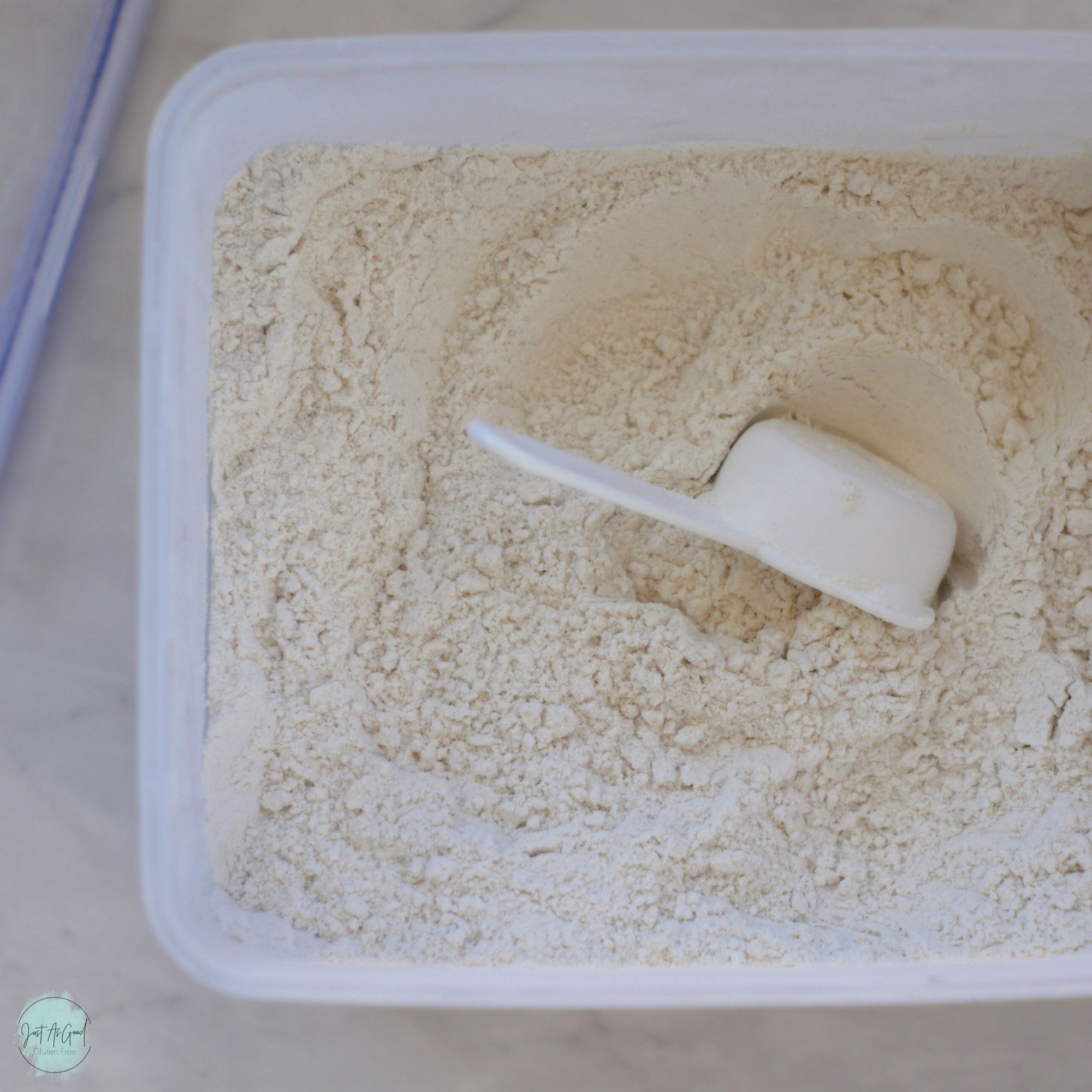 looking inside container of gluten free flour with measuring cup