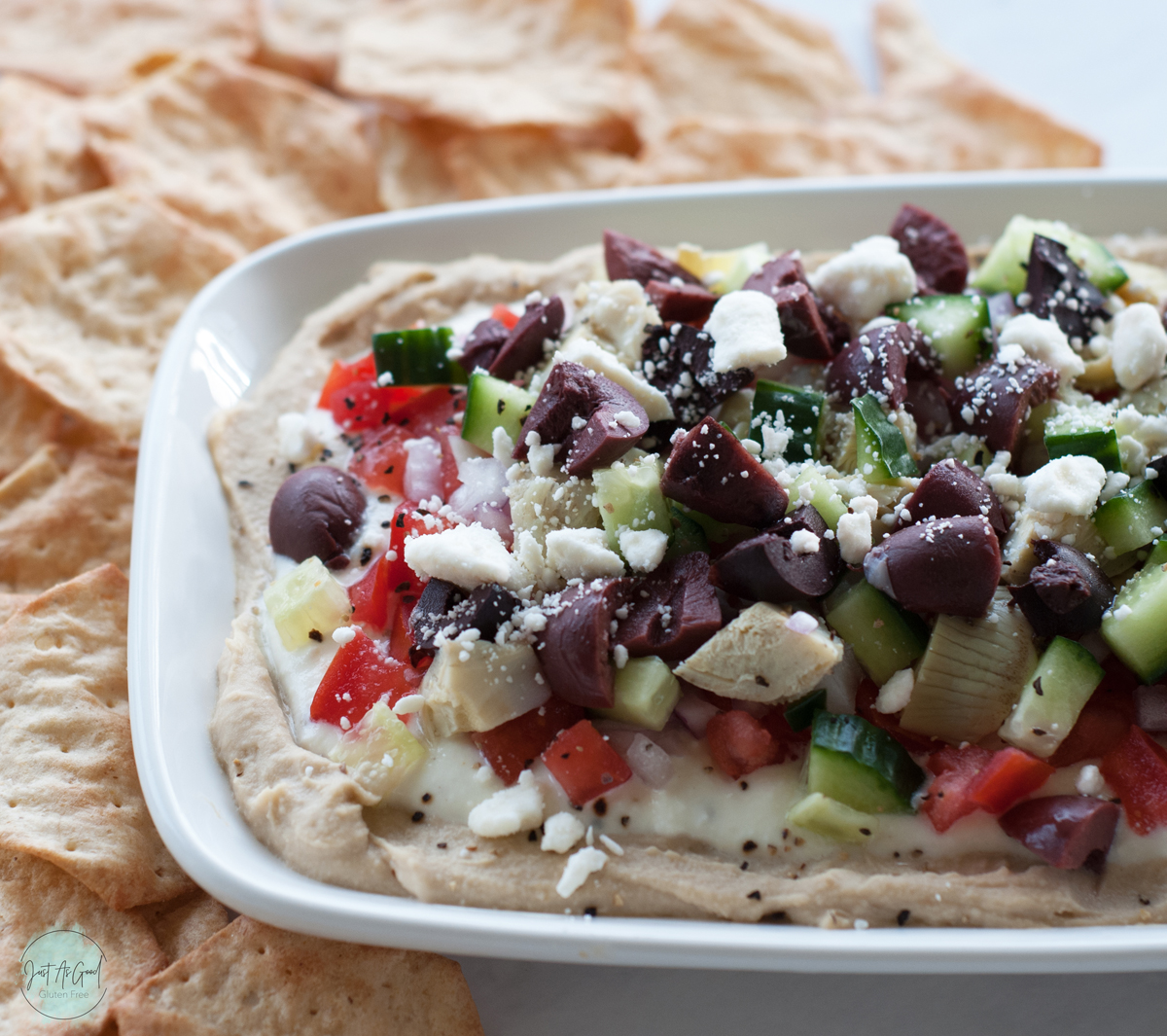 a bird eye view of 7 layer Mediterranean dip with crackers