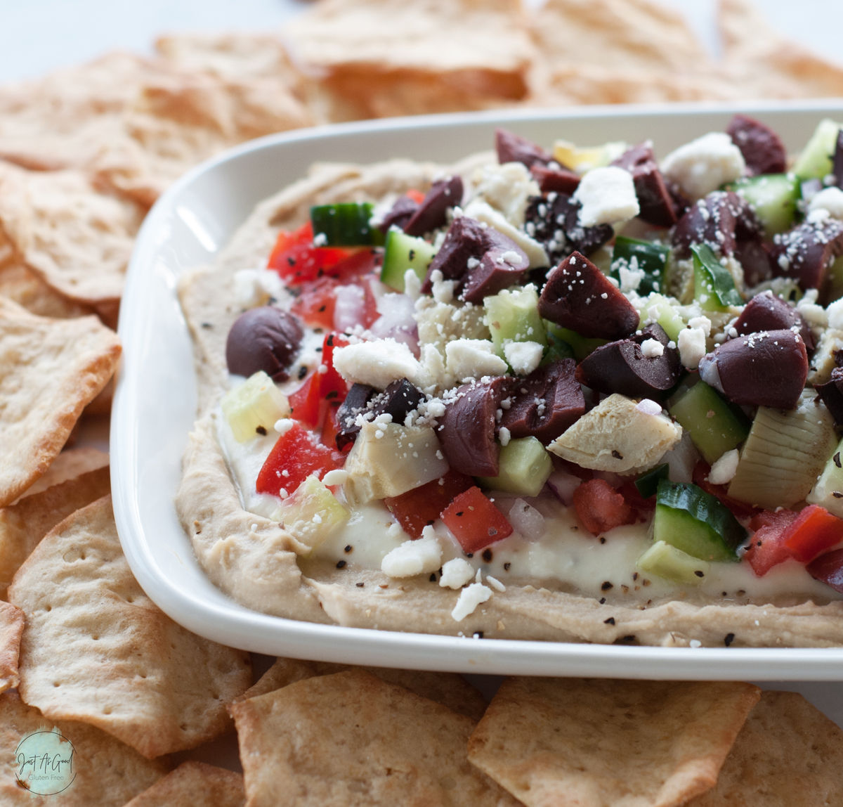 a side view of the layers of 7 Layer Mediterranean Dip with crackers