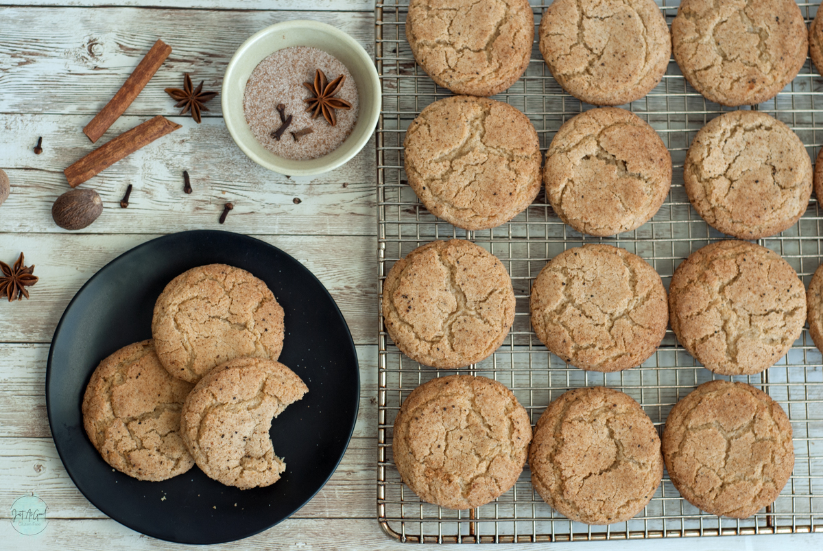 a cooling rack of gluten free chai snickerdoodles next to a plate of cookies